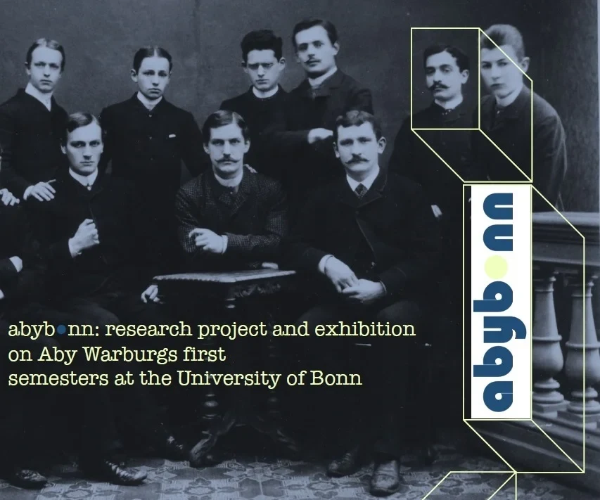 Eine Wissenschaftlerin und ein Wissenschaftler arbeiten hinter einer Glasfassade und mischen Chemikalien mit Großgeräten.