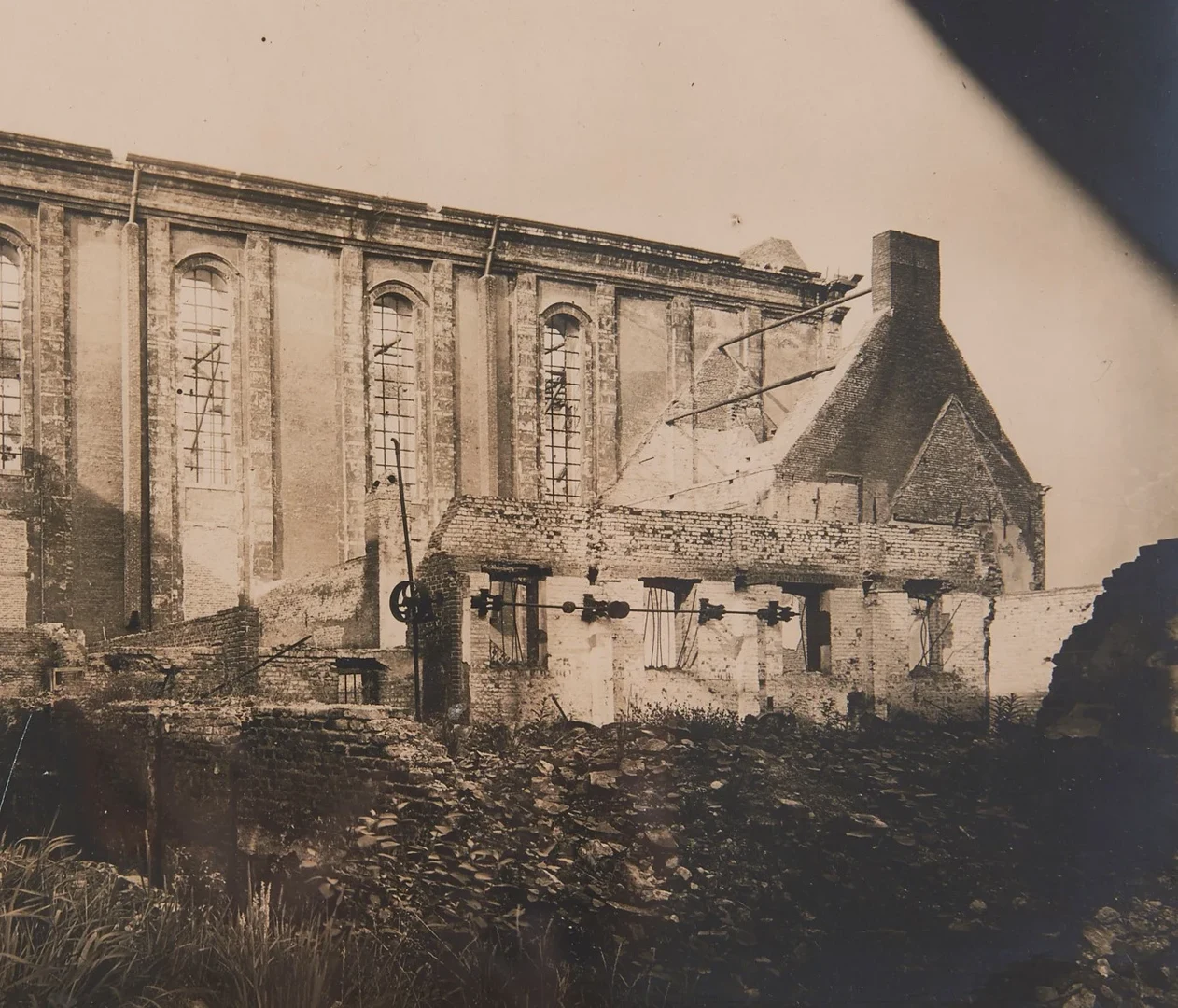 Eine Wissenschaftlerin und ein Wissenschaftler arbeiten hinter einer Glasfassade und mischen Chemikalien mit Großgeräten.