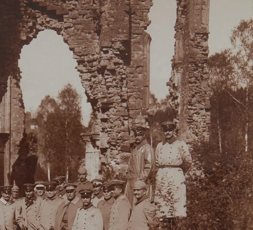 Eine Wissenschaftlerin und ein Wissenschaftler arbeiten hinter einer Glasfassade und mischen Chemikalien mit Großgeräten.