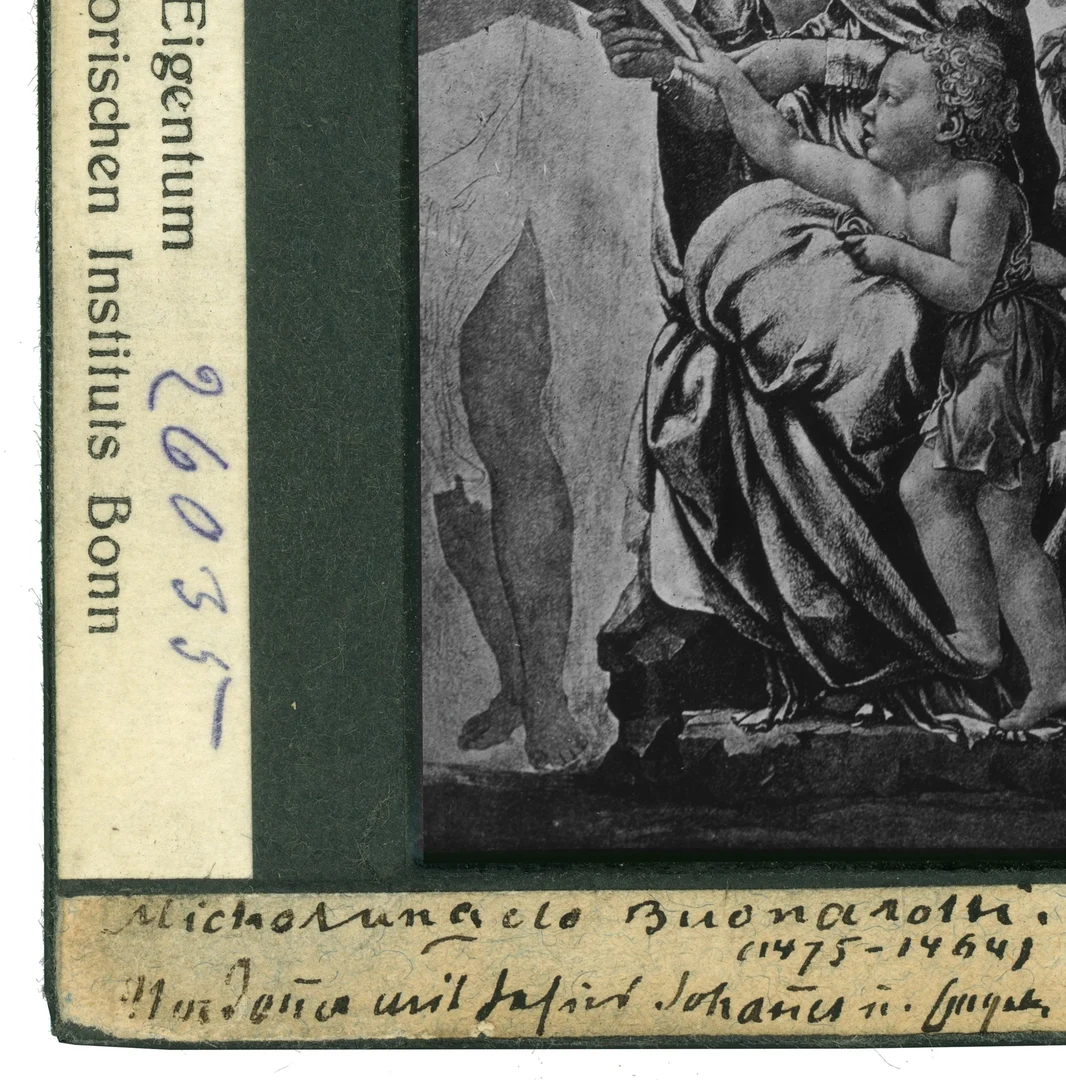 Eine Wissenschaftlerin und ein Wissenschaftler arbeiten hinter einer Glasfassade und mischen Chemikalien mit Großgeräten.