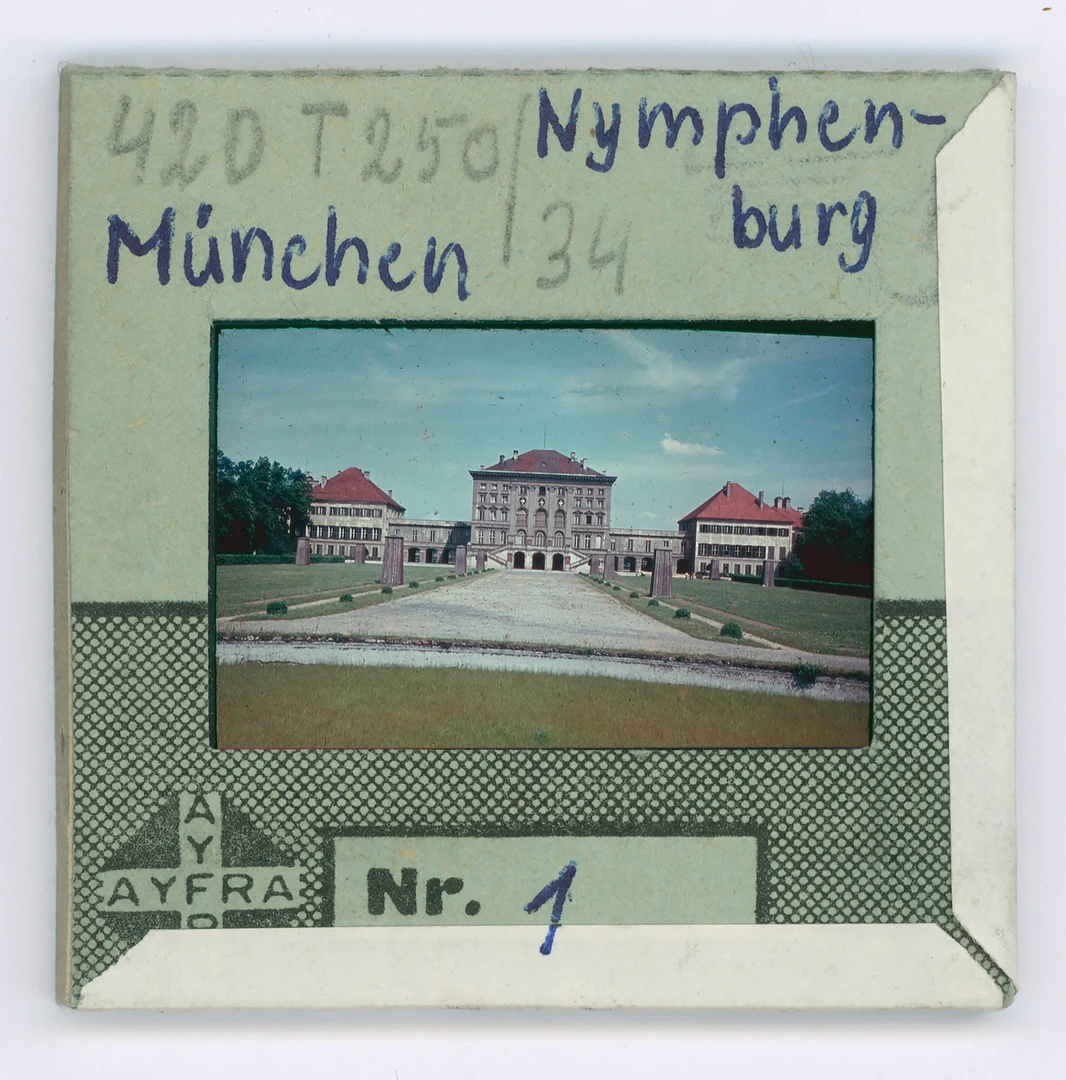 Eine Wissenschaftlerin und ein Wissenschaftler arbeiten hinter einer Glasfassade und mischen Chemikalien mit Großgeräten.