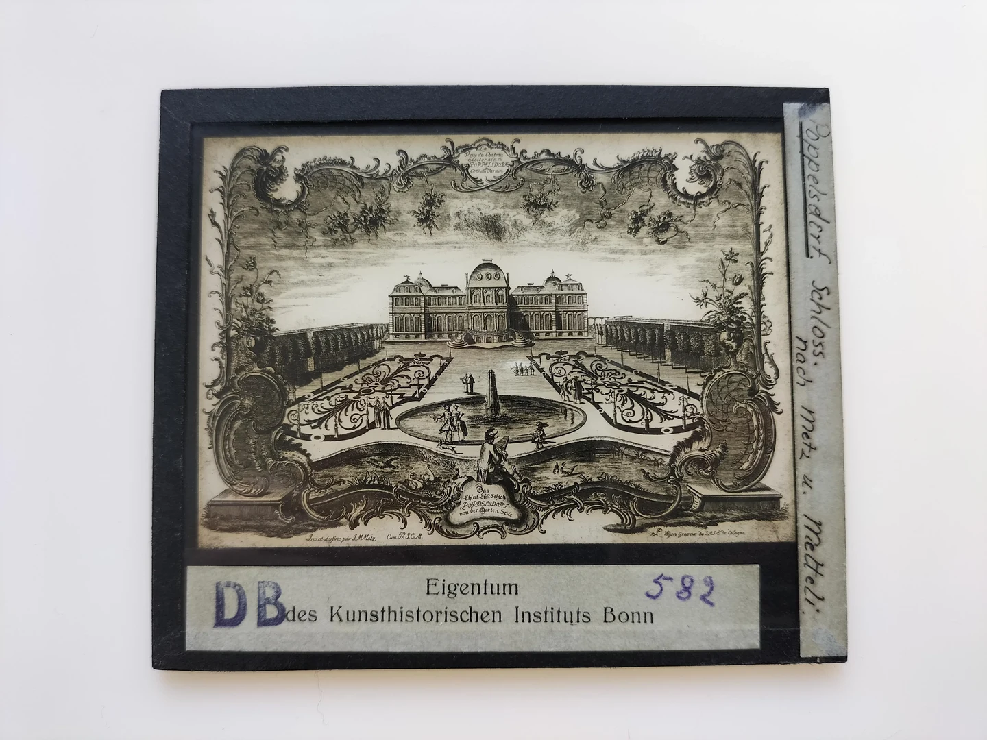 Eine Wissenschaftlerin und ein Wissenschaftler arbeiten hinter einer Glasfassade und mischen Chemikalien mit Großgeräten.