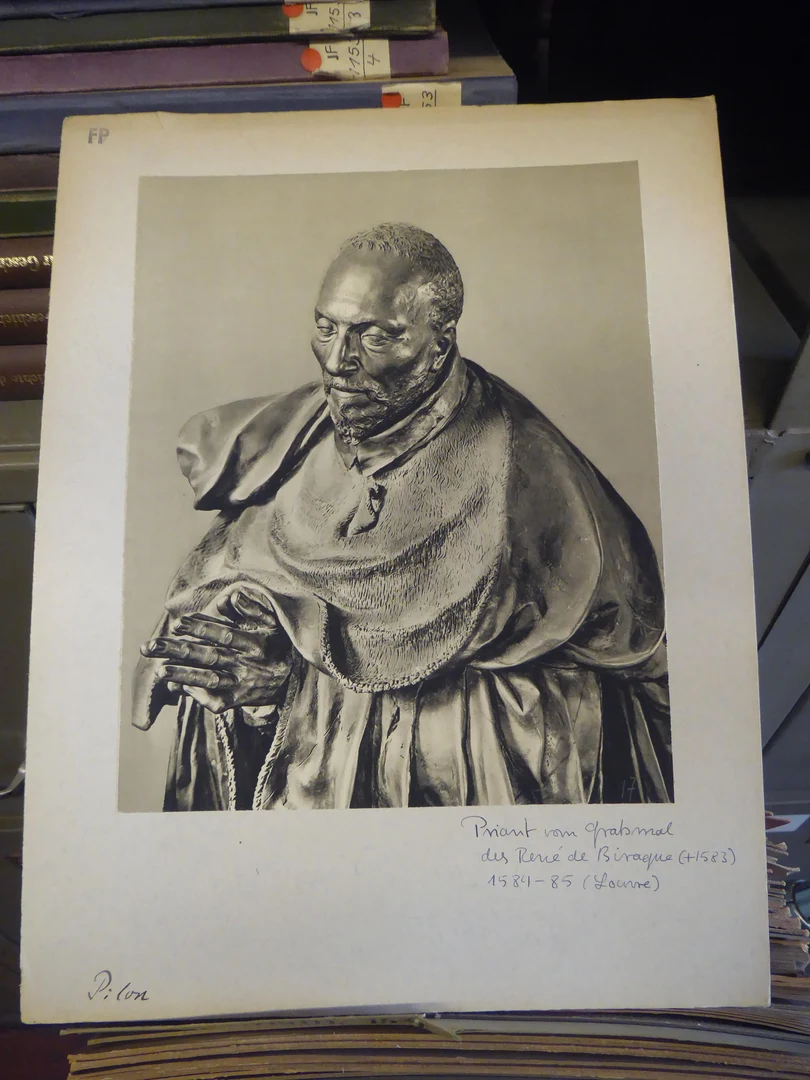 Eine Wissenschaftlerin und ein Wissenschaftler arbeiten hinter einer Glasfassade und mischen Chemikalien mit Großgeräten.