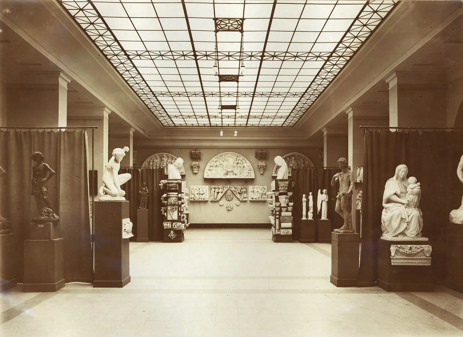 Eine Wissenschaftlerin und ein Wissenschaftler arbeiten hinter einer Glasfassade und mischen Chemikalien mit Großgeräten.