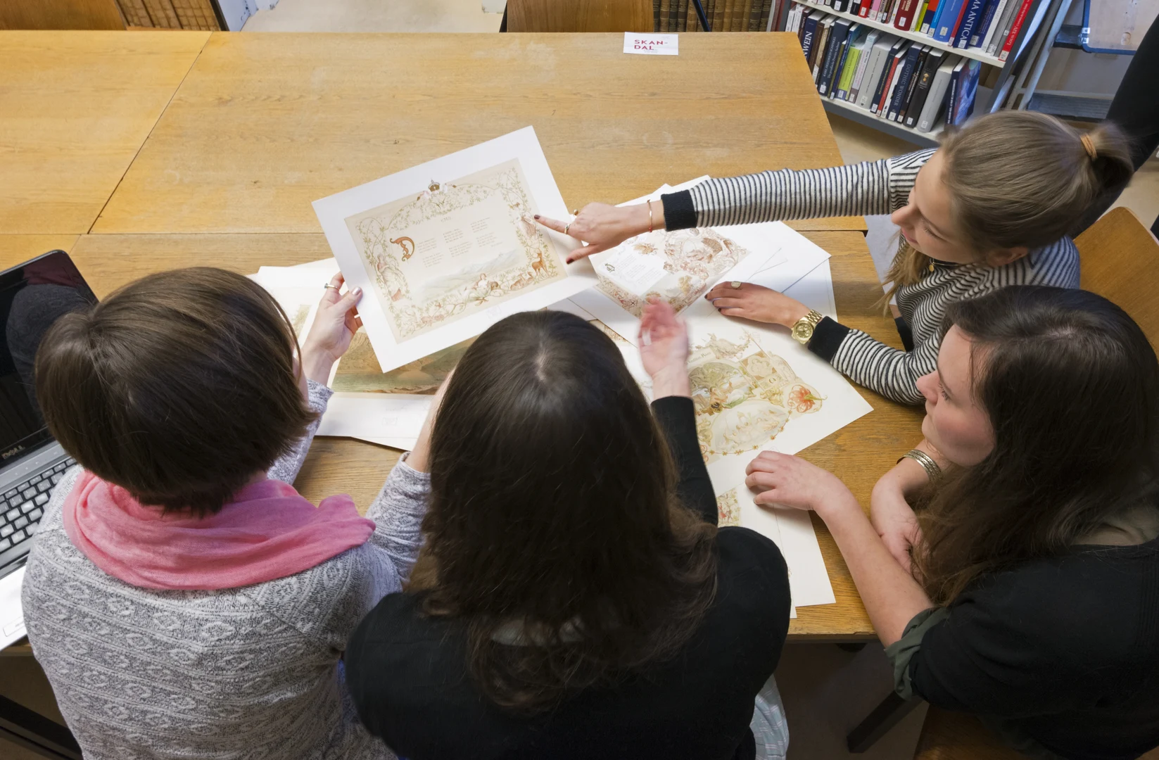 Eine Wissenschaftlerin und ein Wissenschaftler arbeiten hinter einer Glasfassade und mischen Chemikalien mit Großgeräten.